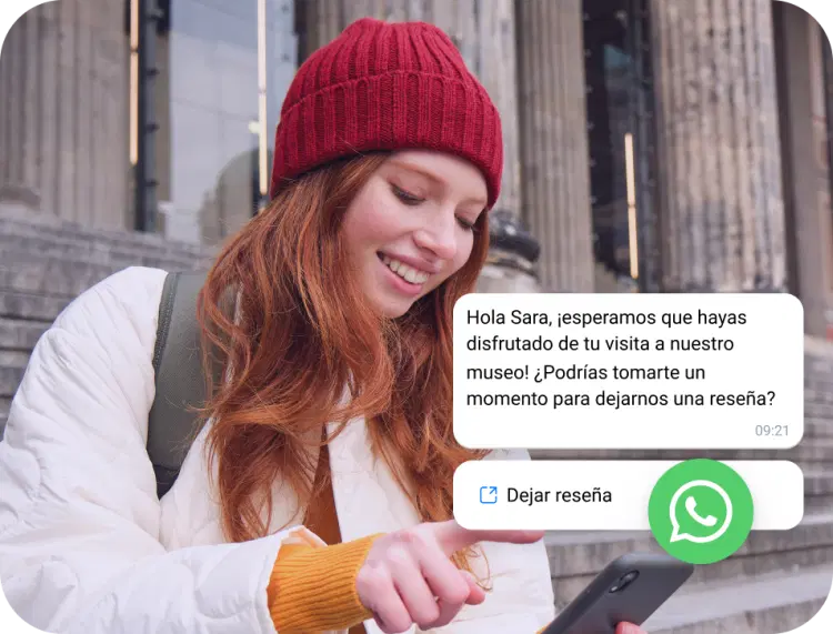 Chica con gorra roja leyendo un mensaje comercial de WhatsApp en su teléfono