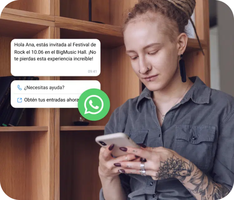 Chica con un tatuaje revisando su teléfono en busca de una invitación a un festival de rock recibida a través de WhatsApp