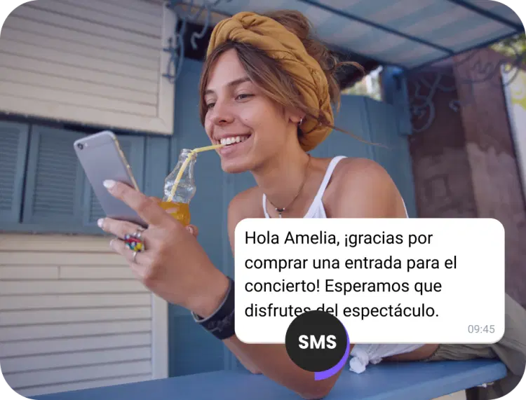 Chica bebiendo jugo en la calle revisando un SMS de confirmación de una entrada para un concierto