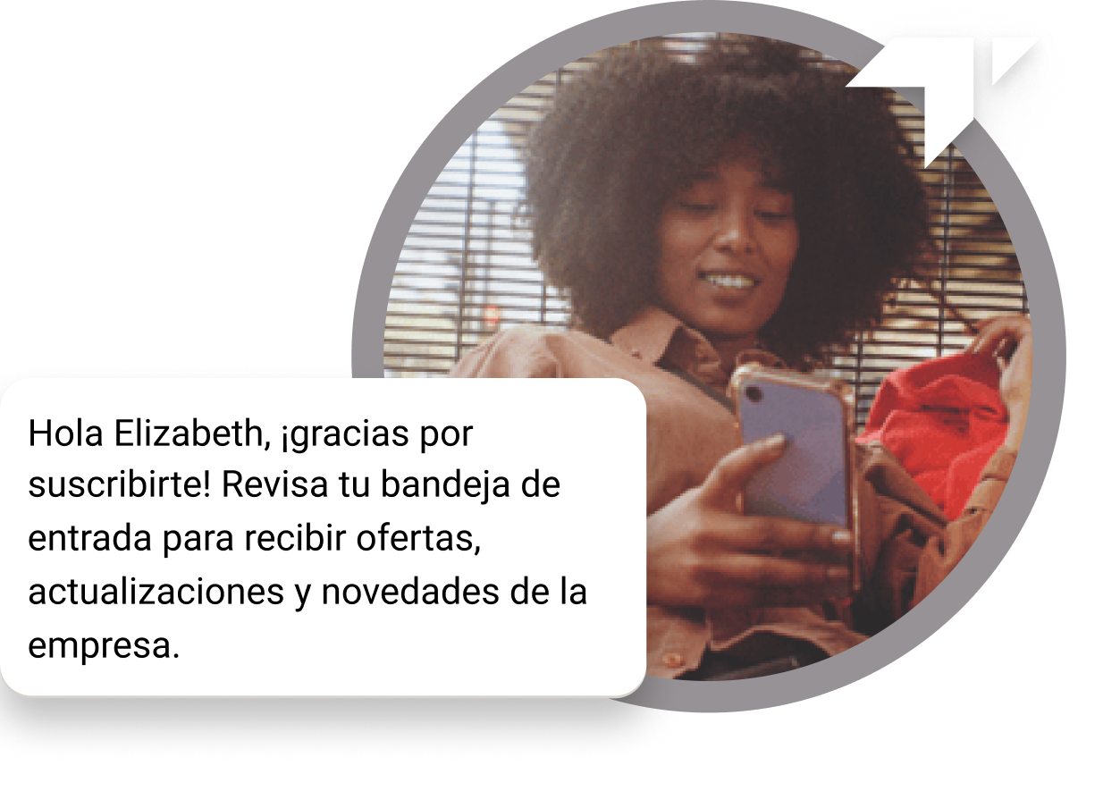 Chica de cabello rizado sentada en el piso mirando su teléfono en busca de un mensaje de agradecimiento recibido por su suscripción