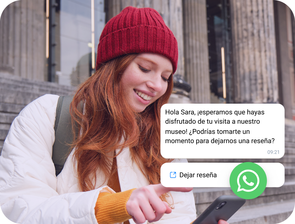 Chica con gorra roja leyendo un mensaje de WhatsApp Business en su teléfono
