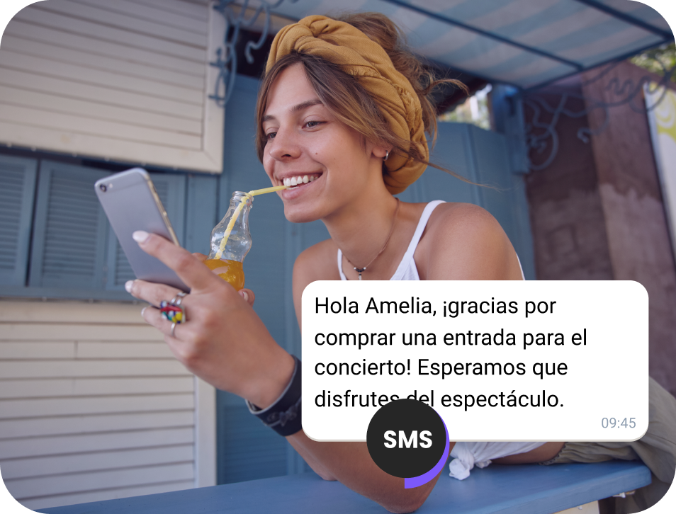 Chica bebiendo jugo en la calle revisando un SMS de confirmación para un boleto de concierto